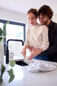 happy couple hugging by kitchen sink